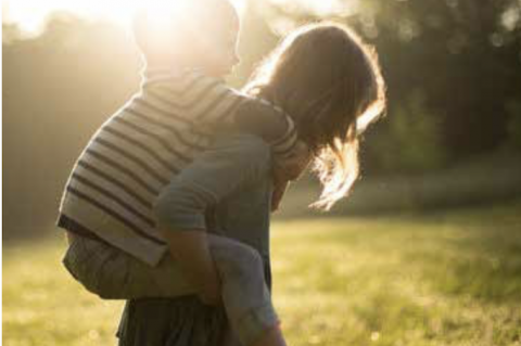 Woman carrying small child on her back