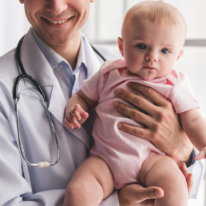 Doctor holding baby sitting up with stethoscope